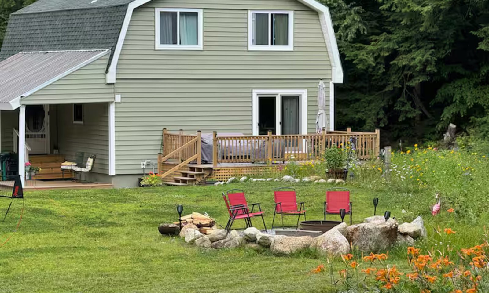 Valley House seen from the back lawn, with the deck and stone fire pit in the foreground