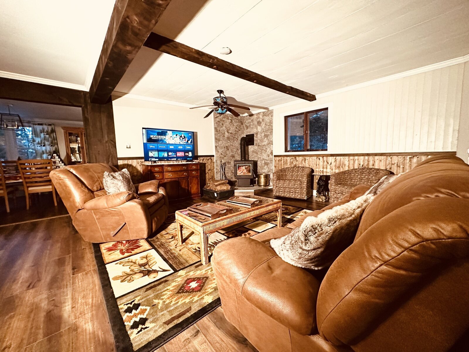 The living room at Valley House with the wood stove and leather sofas
